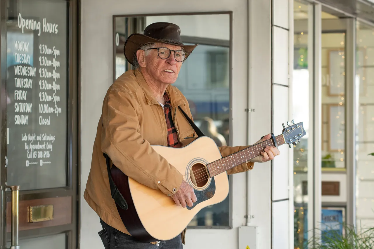 Man busking playing guitar