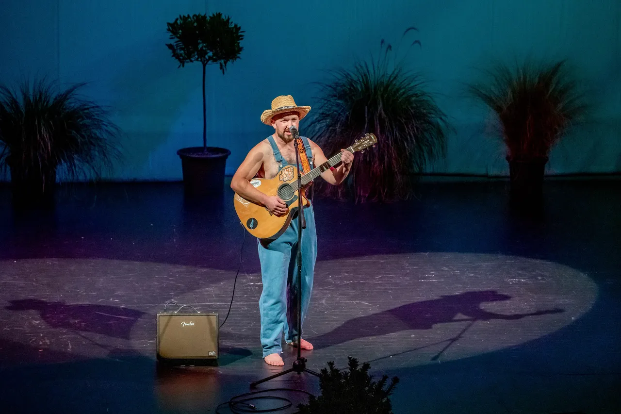 man on stage with guitar