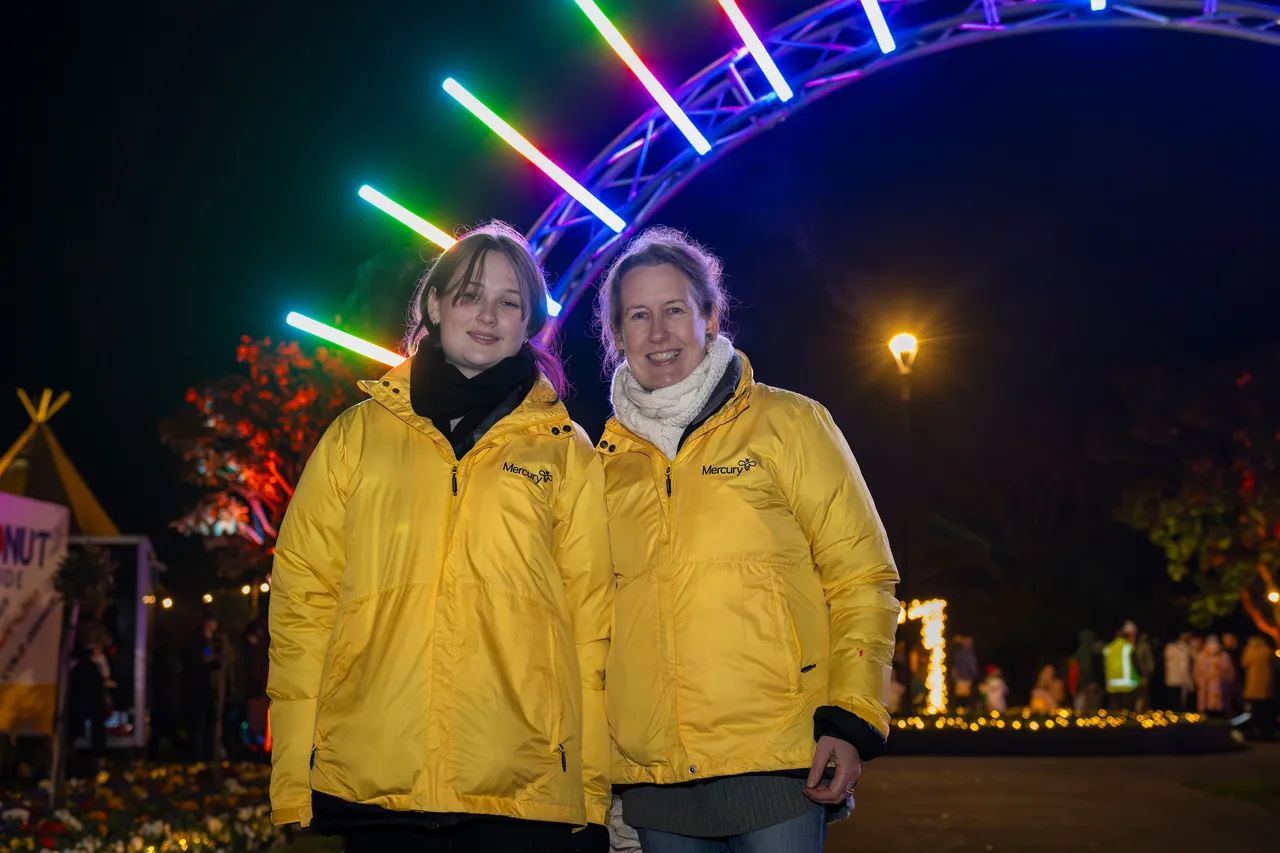 Two Mercury staff attending Kahui Whetu. Lights in background.