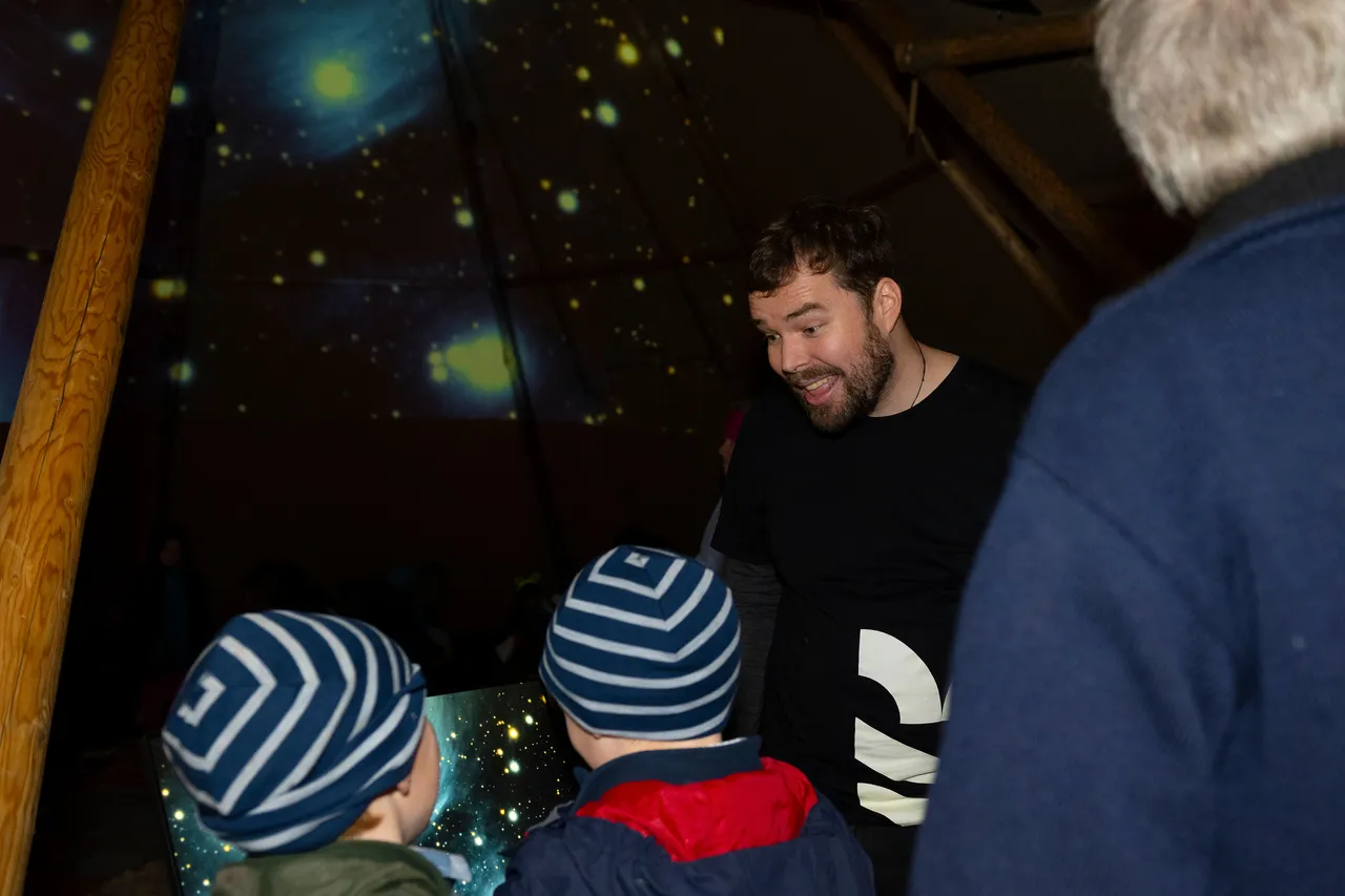 Otago Museum man talking to two children in tipi with star computer screen