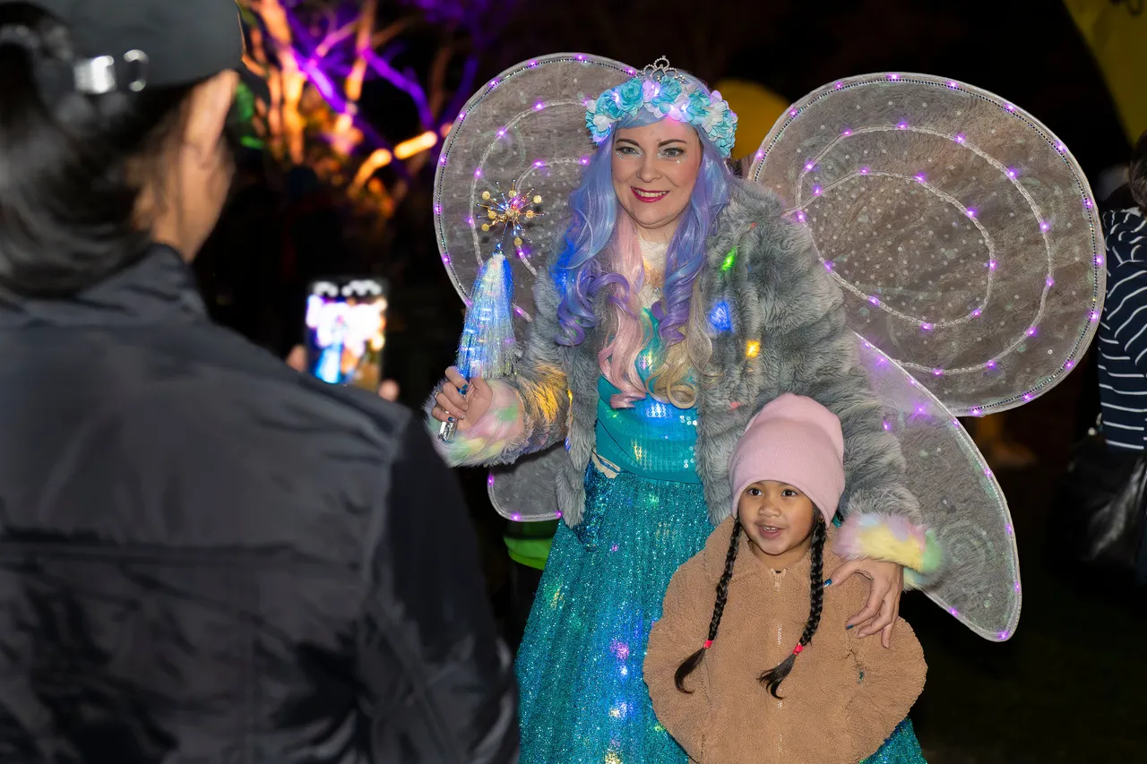 Person taking photo of glow fairy and child