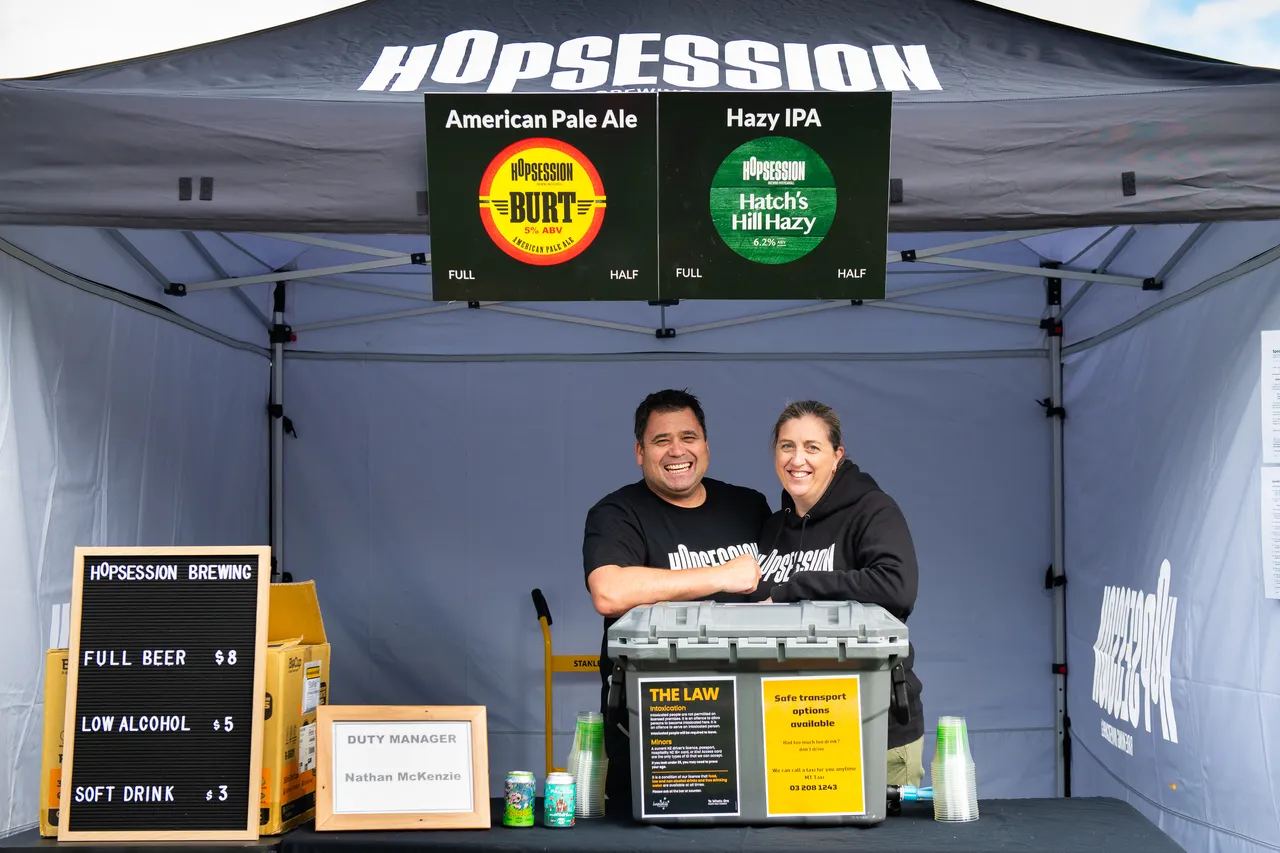 Two people smiling by a cooler