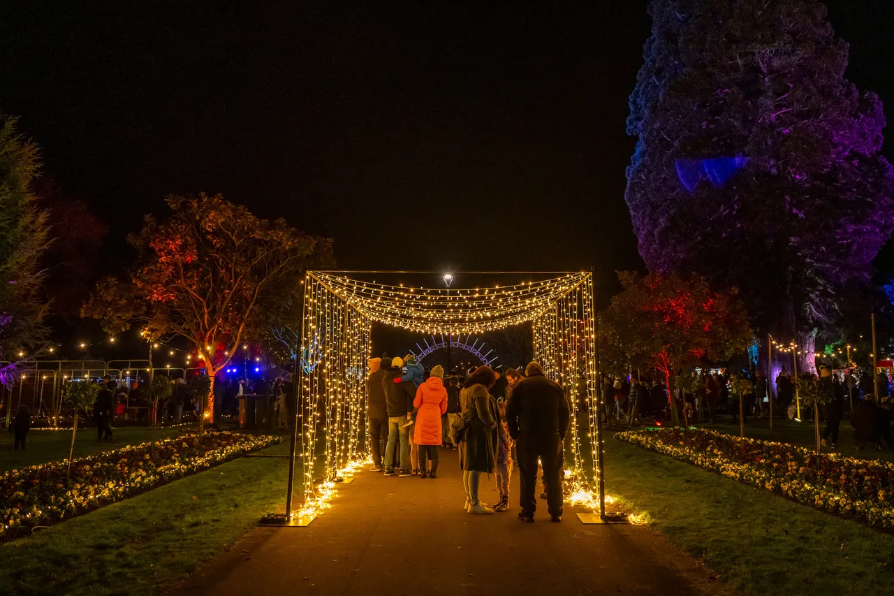 Fairy light walk through display arch. people walking through.