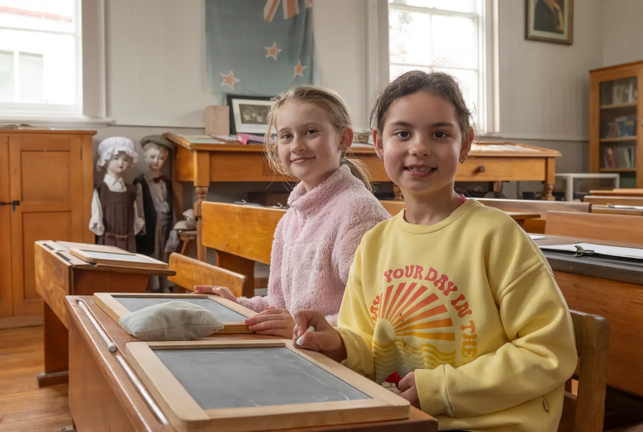 two young girls siting at desks