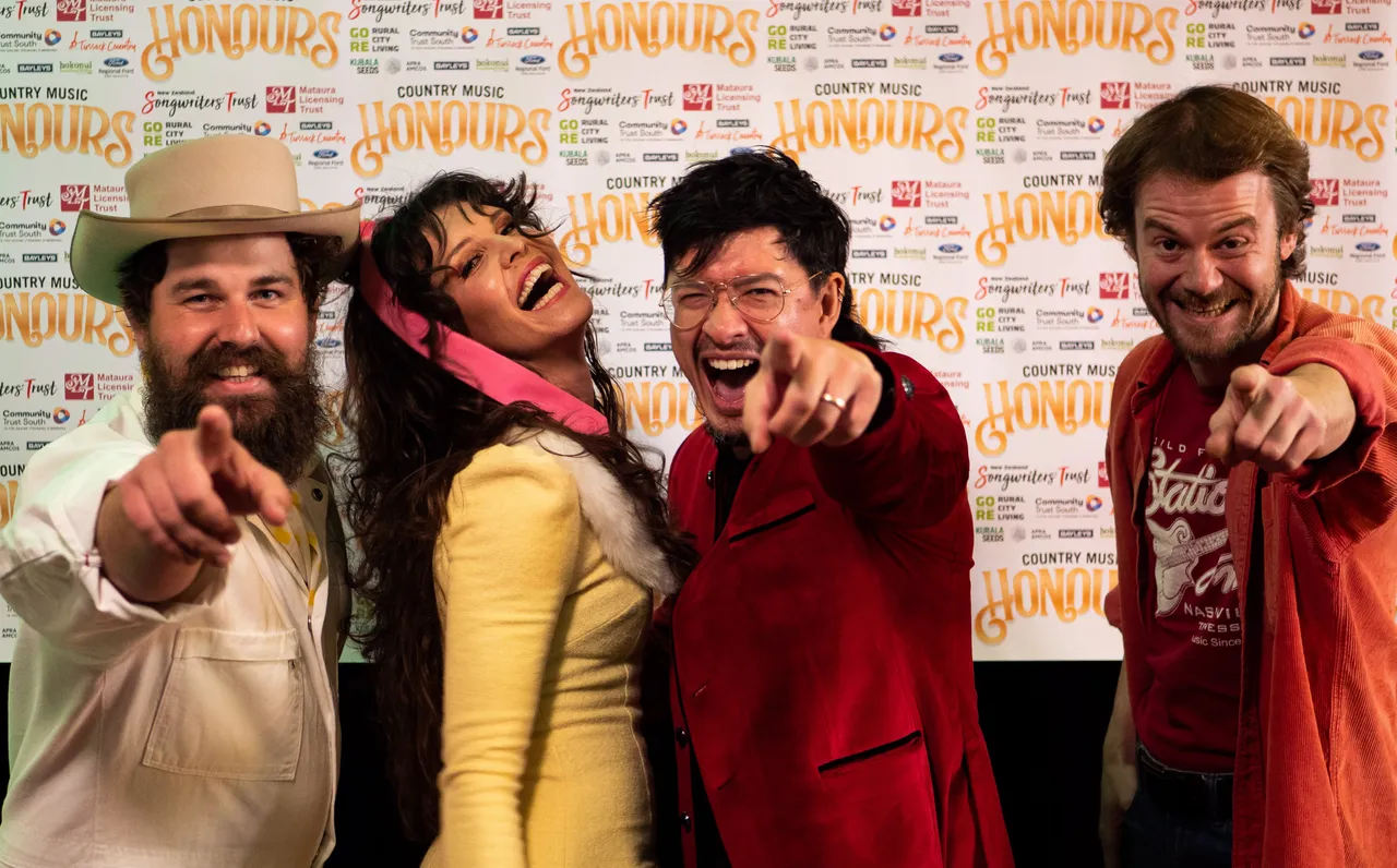 Musicians point at camera and smile