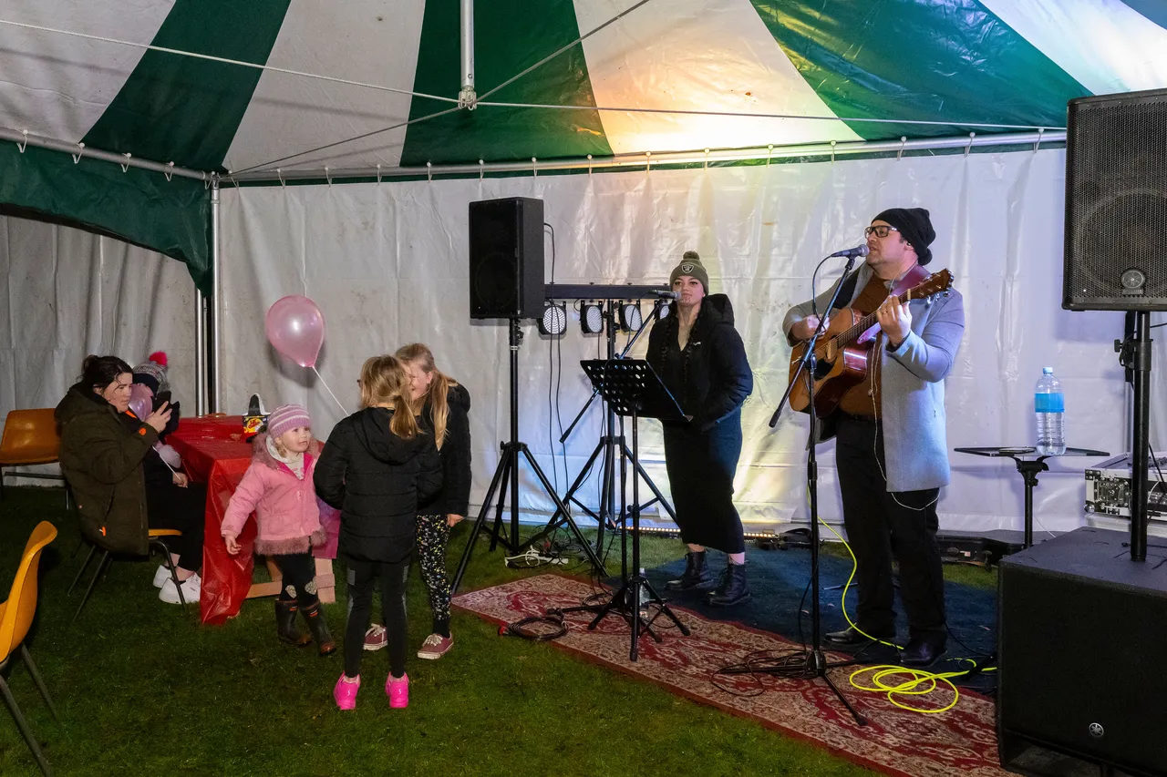Musicians playing to group of children dancing.
