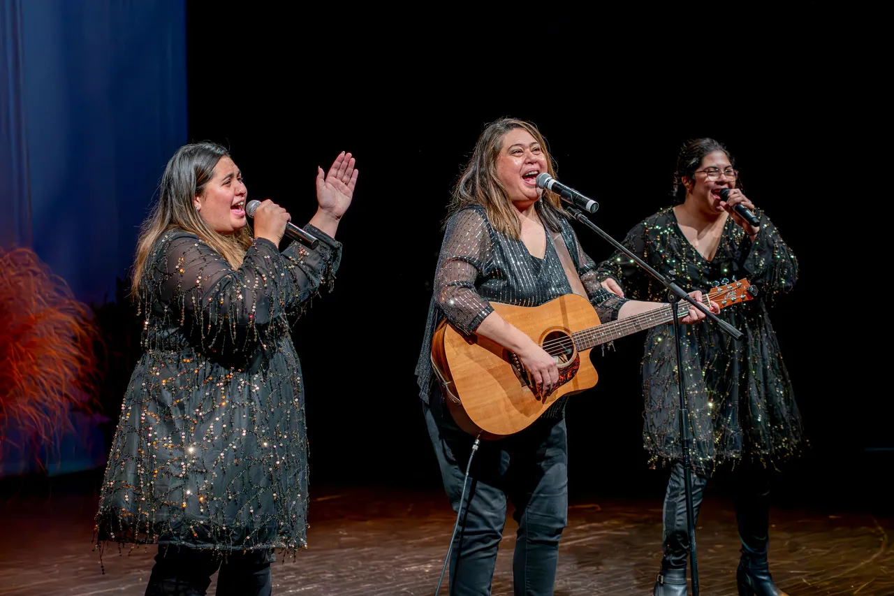 Three women performing on a stage.