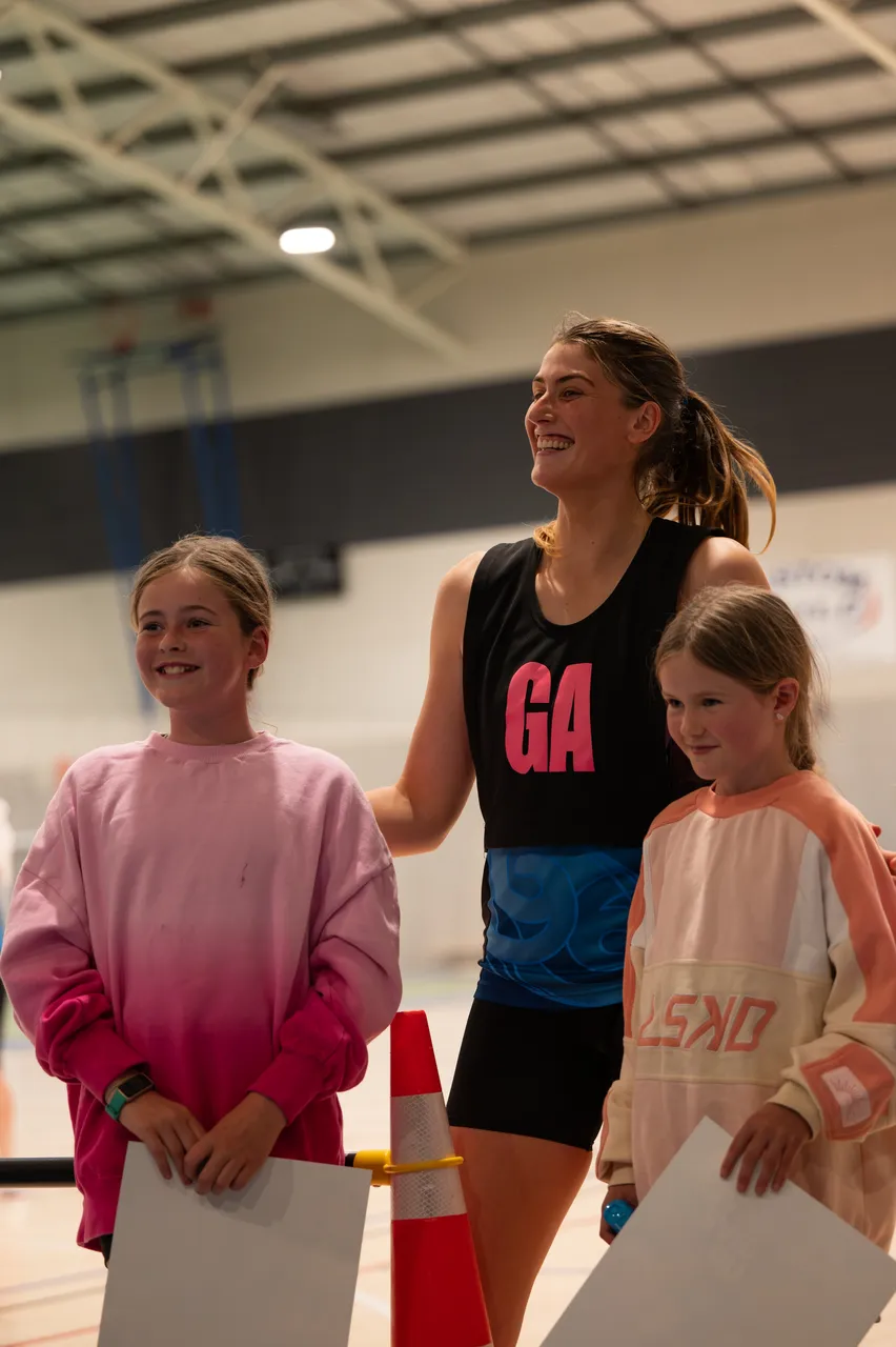 Children pose with netball player