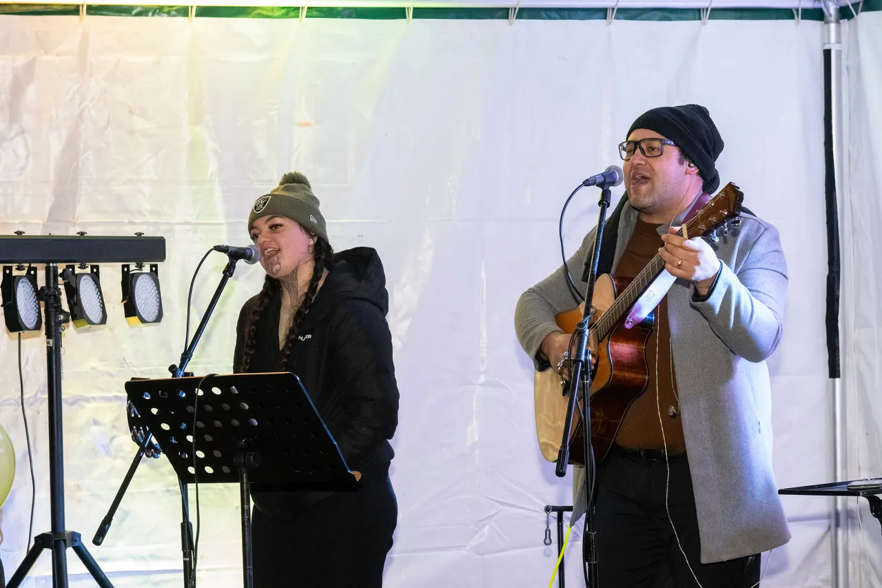 man and woman singing, man playing guitar.