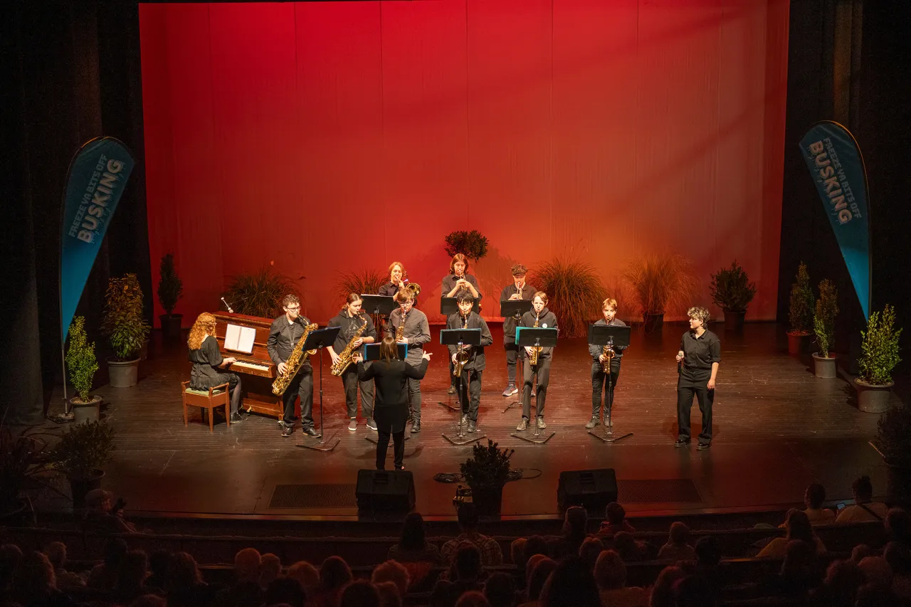 A large group of musicians performing on a stage