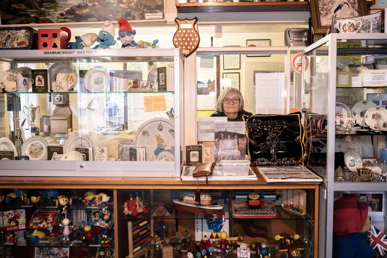woman stands beside antiques