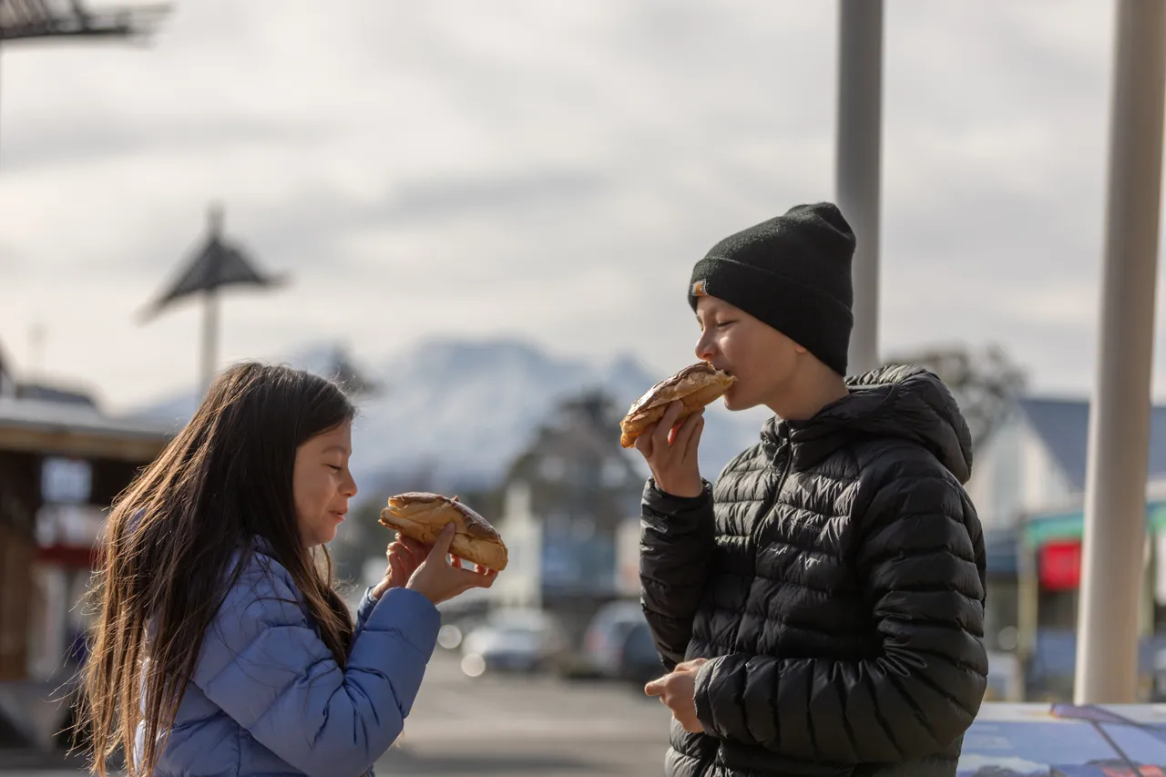 Kids enjoying Ohakune’s famous chocolate eclairs in town centre
