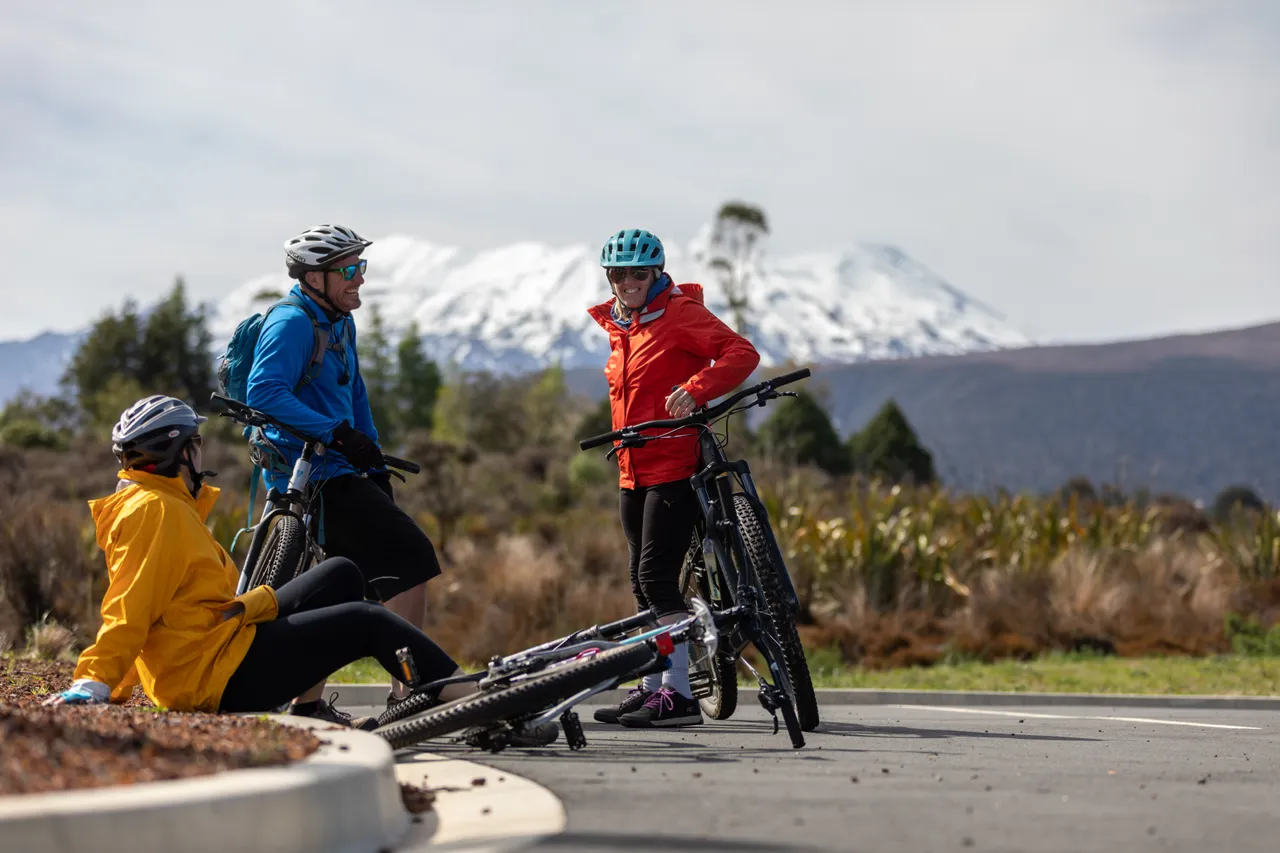 A group of friends laughing while taking a break from mountain biking