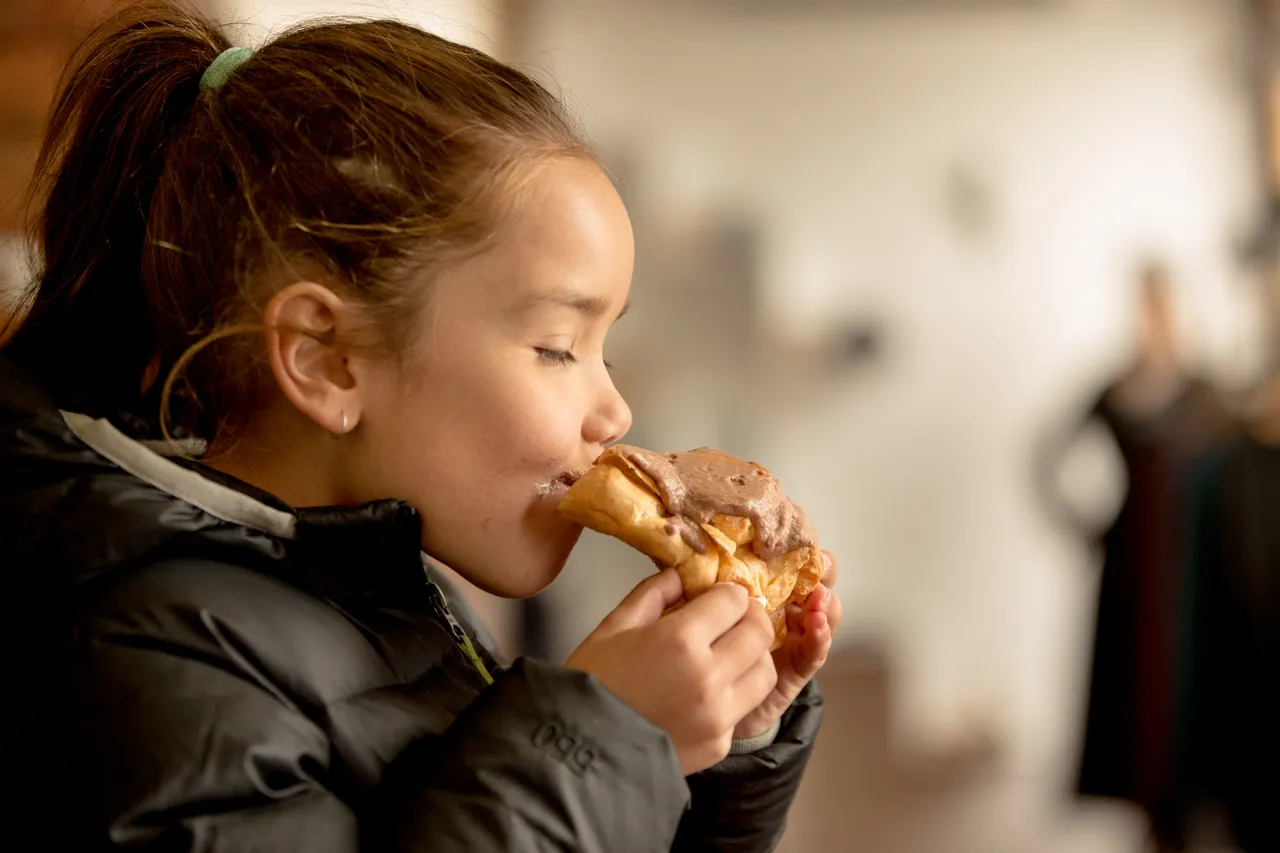 Girl eating a famous Johnny Nations Chocolate Eclair