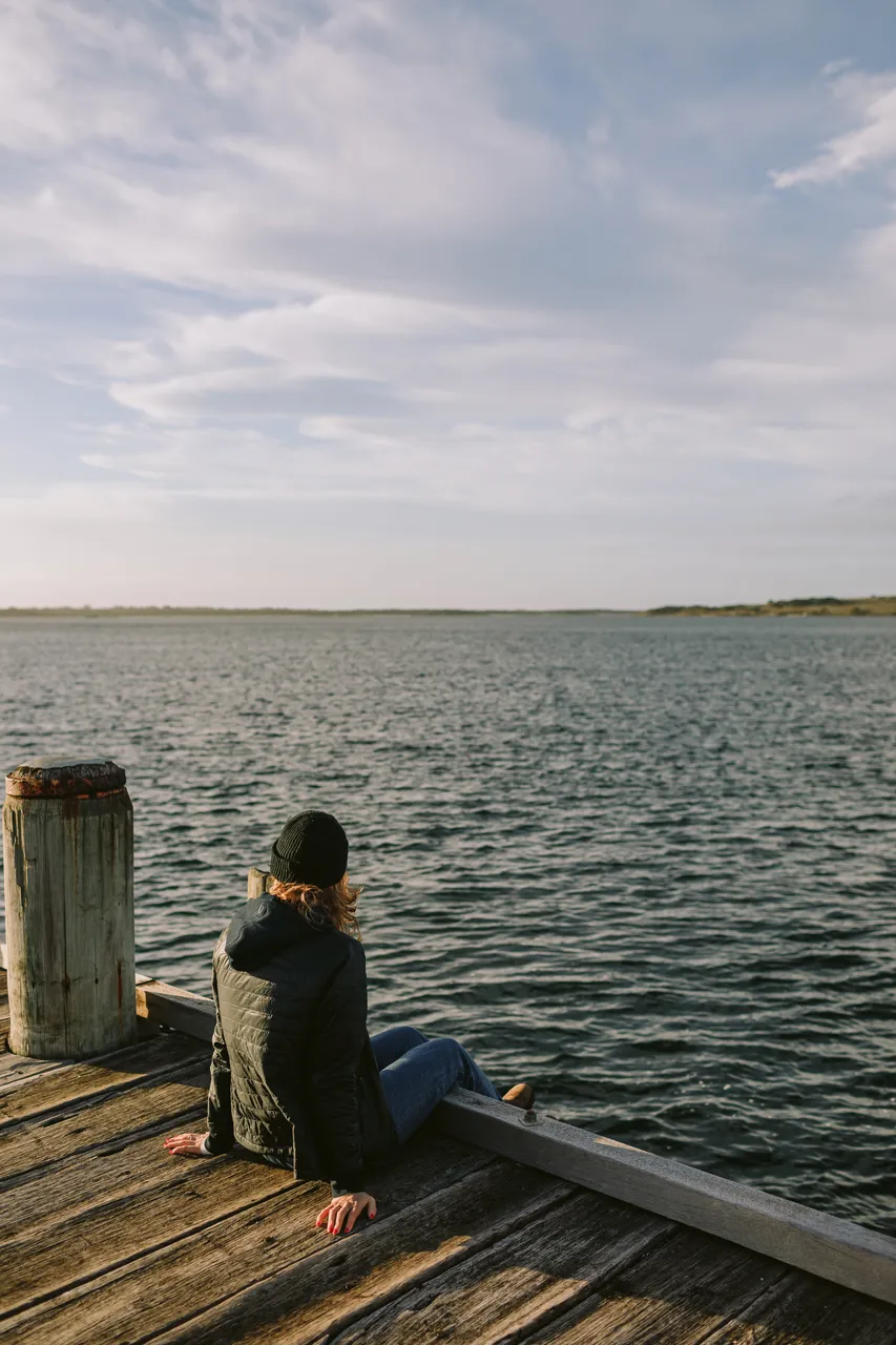 Person Sitting on Pier