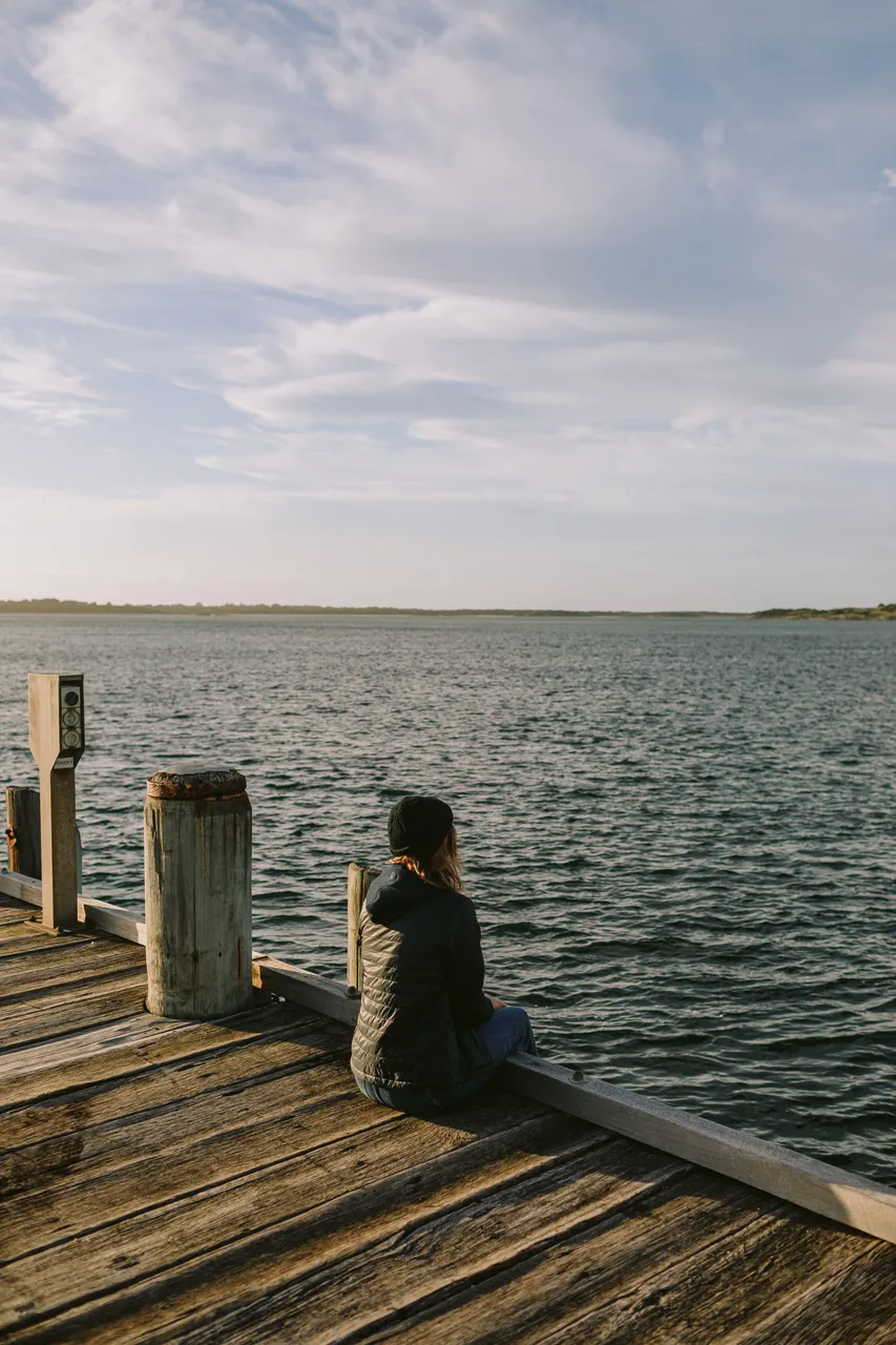 Person Sitting on Pier