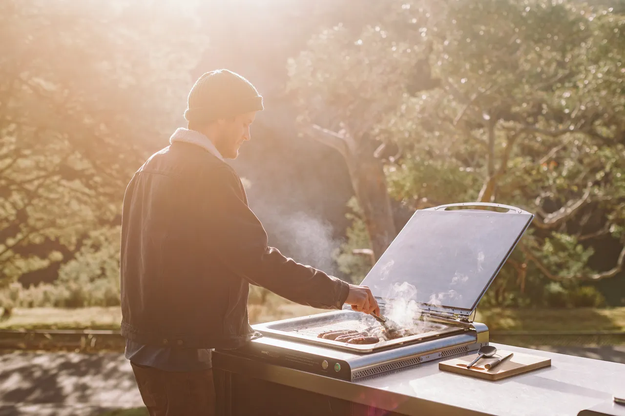 Person Cooking Sausages