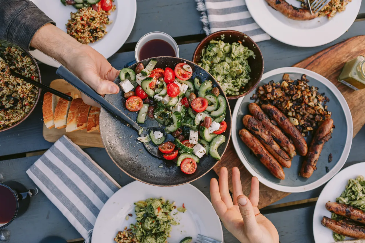 Passing Salad at Picnic Table