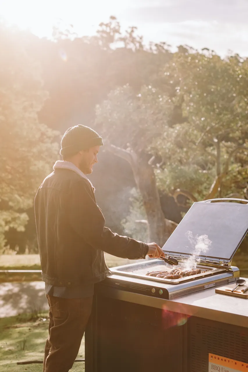 Person Cooking Sausages