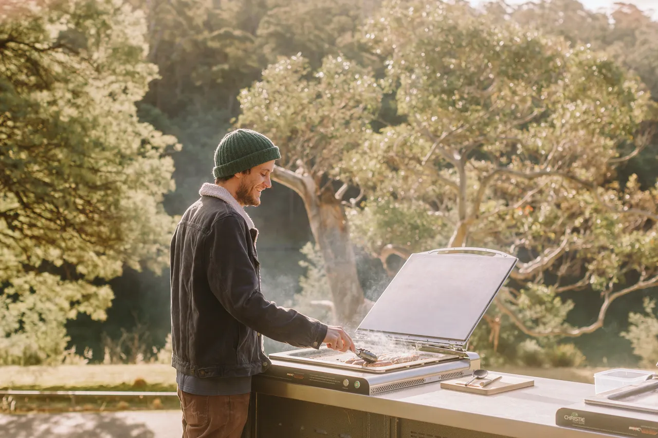 Person Cooking Sausages