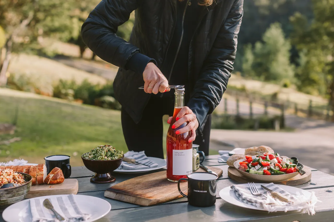 Opening Bottle on Picnic Table