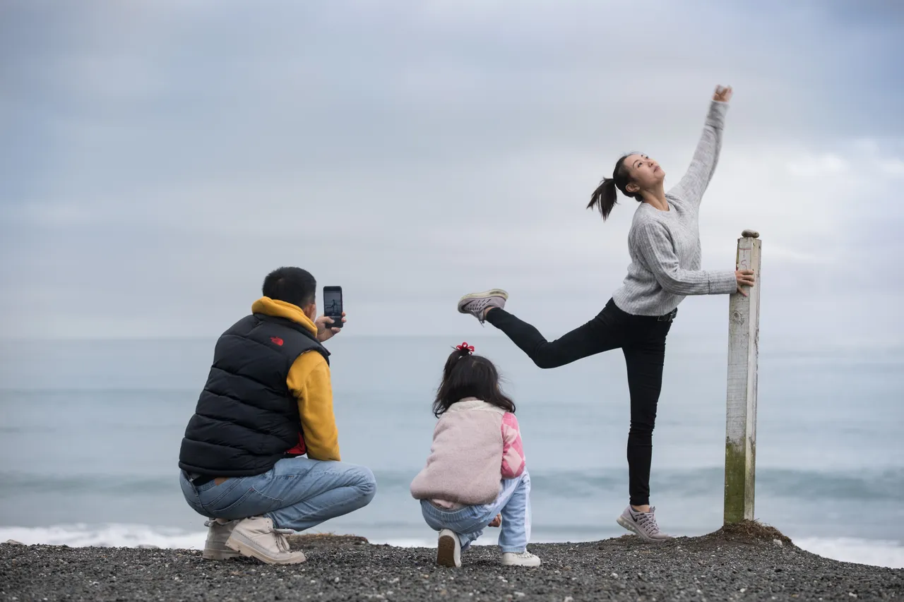 Chinese lady having photos taken while doing ballet poses at Bruce bay