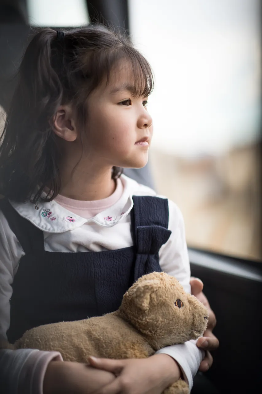 Chinese girl holding a toy inside the bus