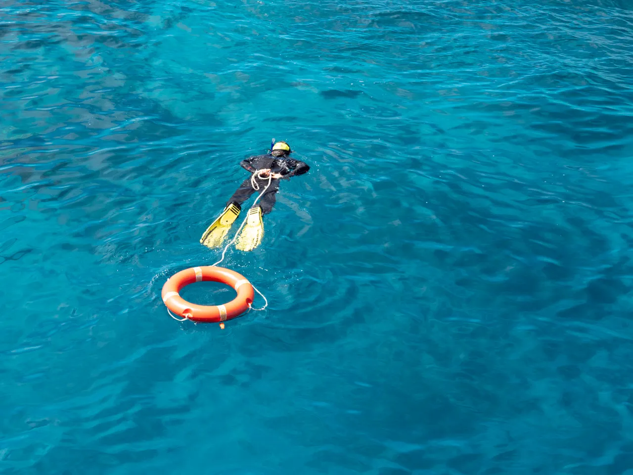 Child snorkeling with a life buoy