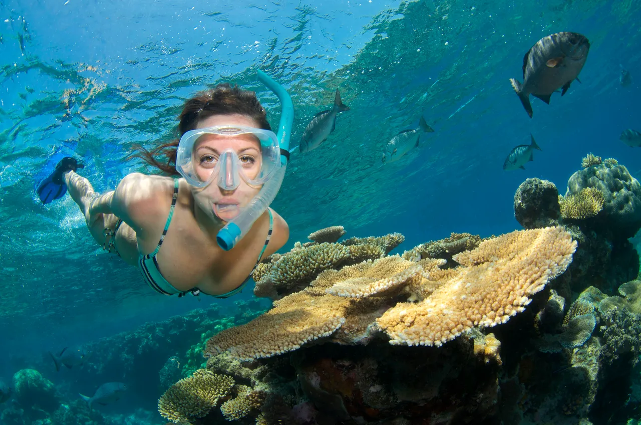 European lady next to a coral reef