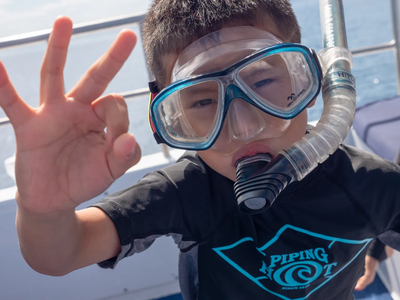 Asian kid with snorkeling gear smiling to the camera