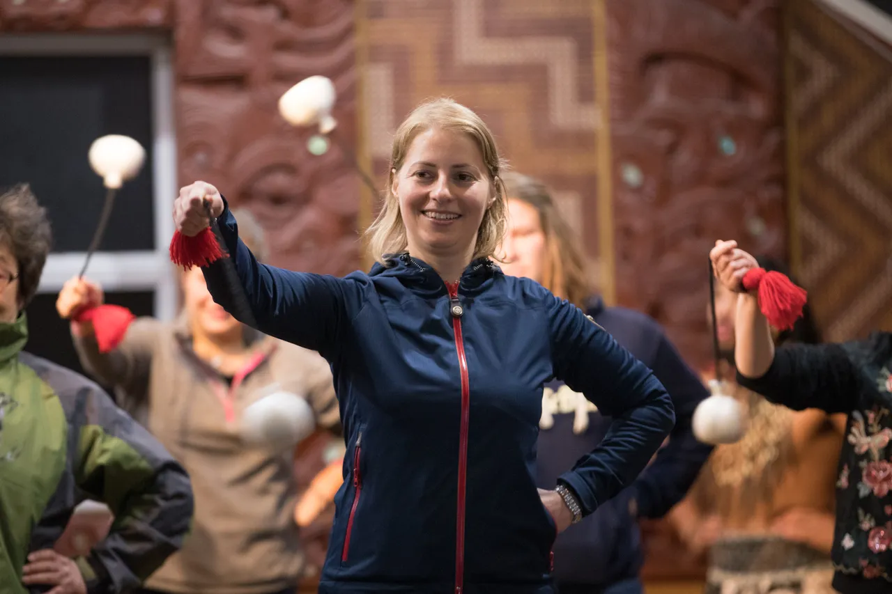 European woman performing with poi at Te Puia