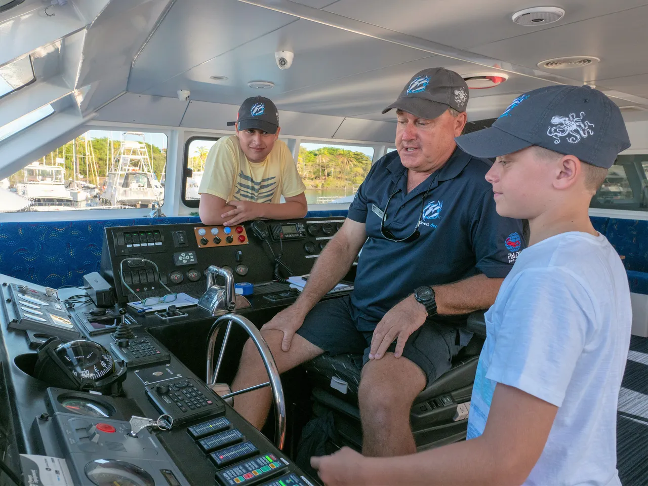 Child being introduced to the vessel controls by male staff