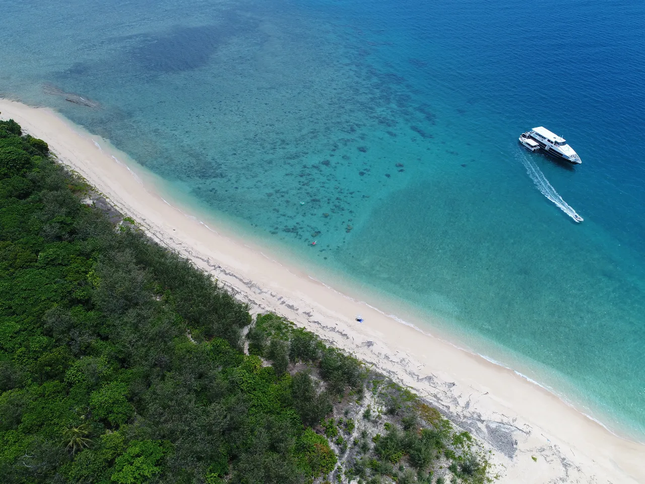 Beach and rainforest with Turtle Islander vessel