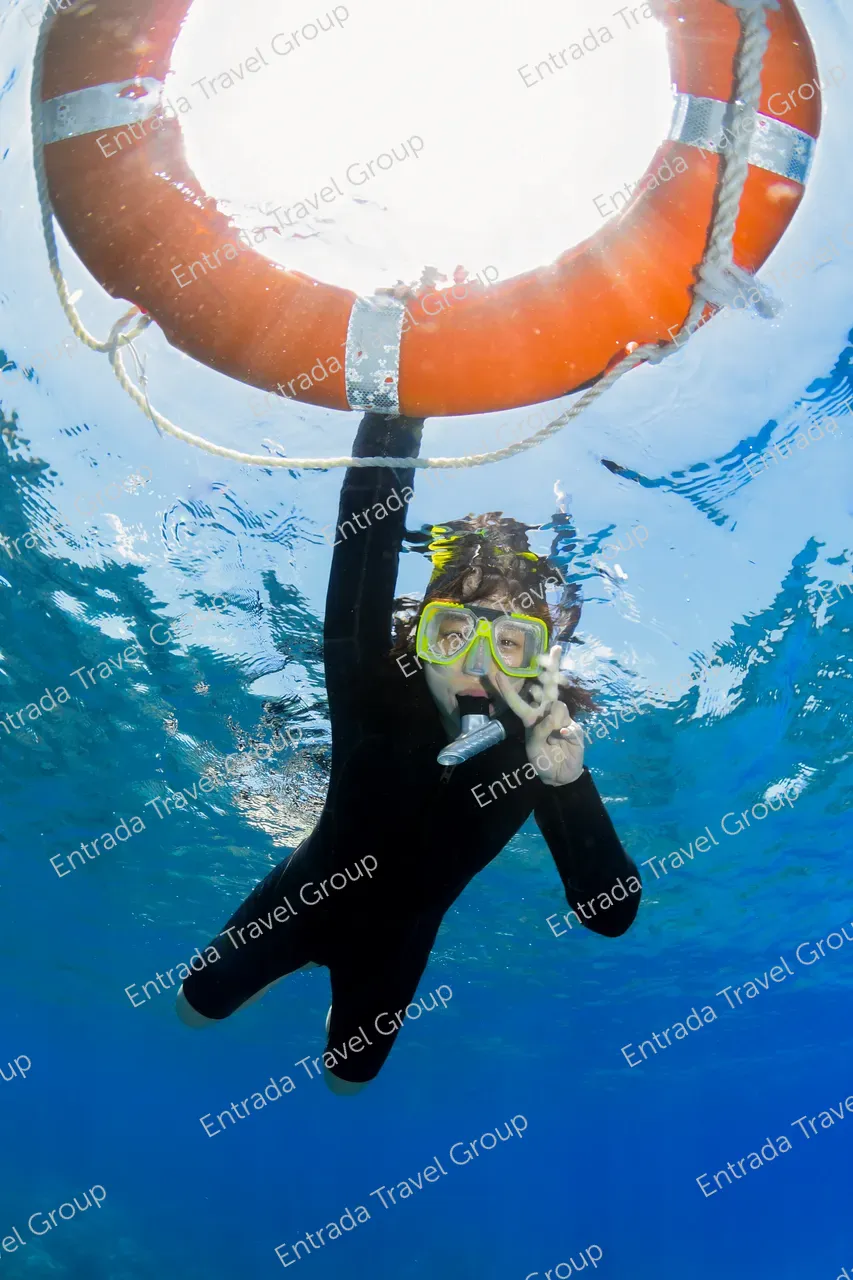 Snorkeler in Great Barrier Reef support by a life ring and giving a peace sign