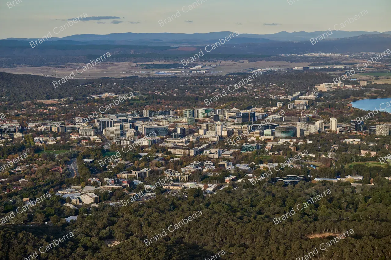 An aerial view over Canberra CBD facing east with Canberra Airport in the distance