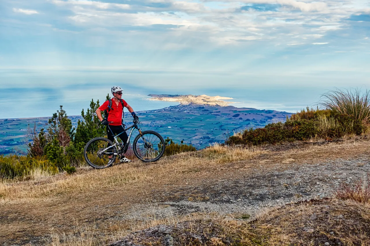 Man on top of mountain, overlooking sea