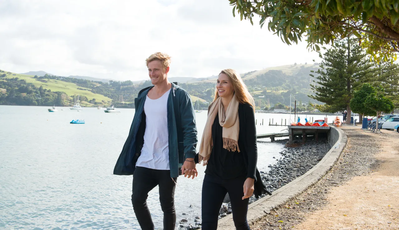 Couple walking along the Akaroa waterfront