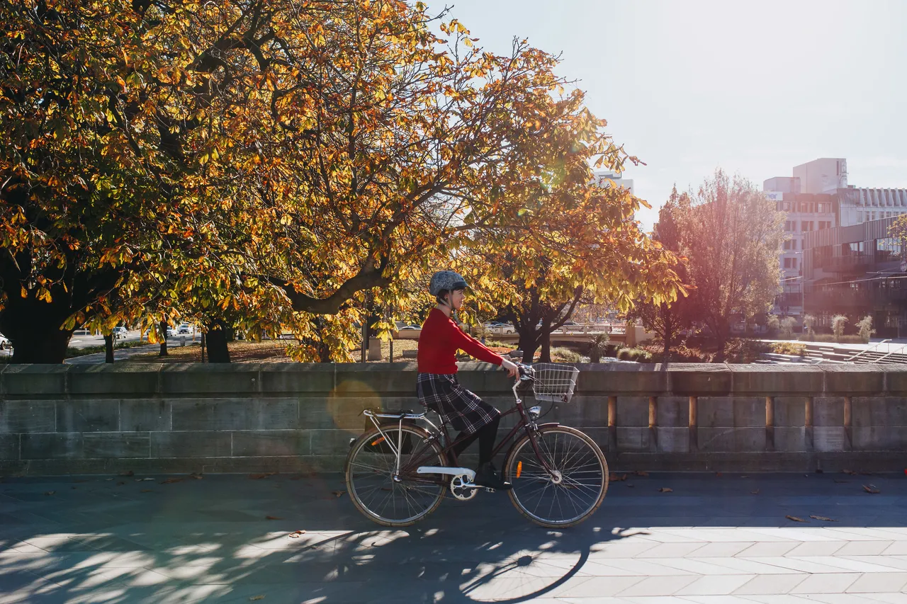 Woman cycling on Bridge in Autumn
