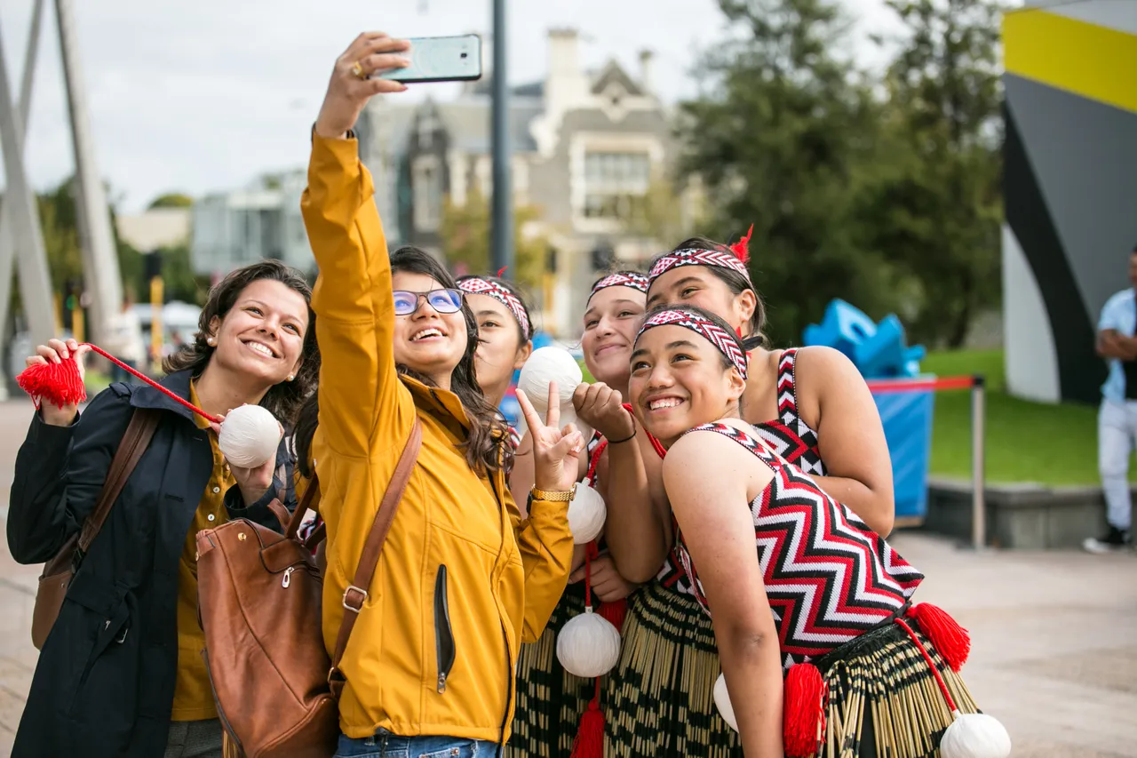 Student taking selfie with kapa haka group