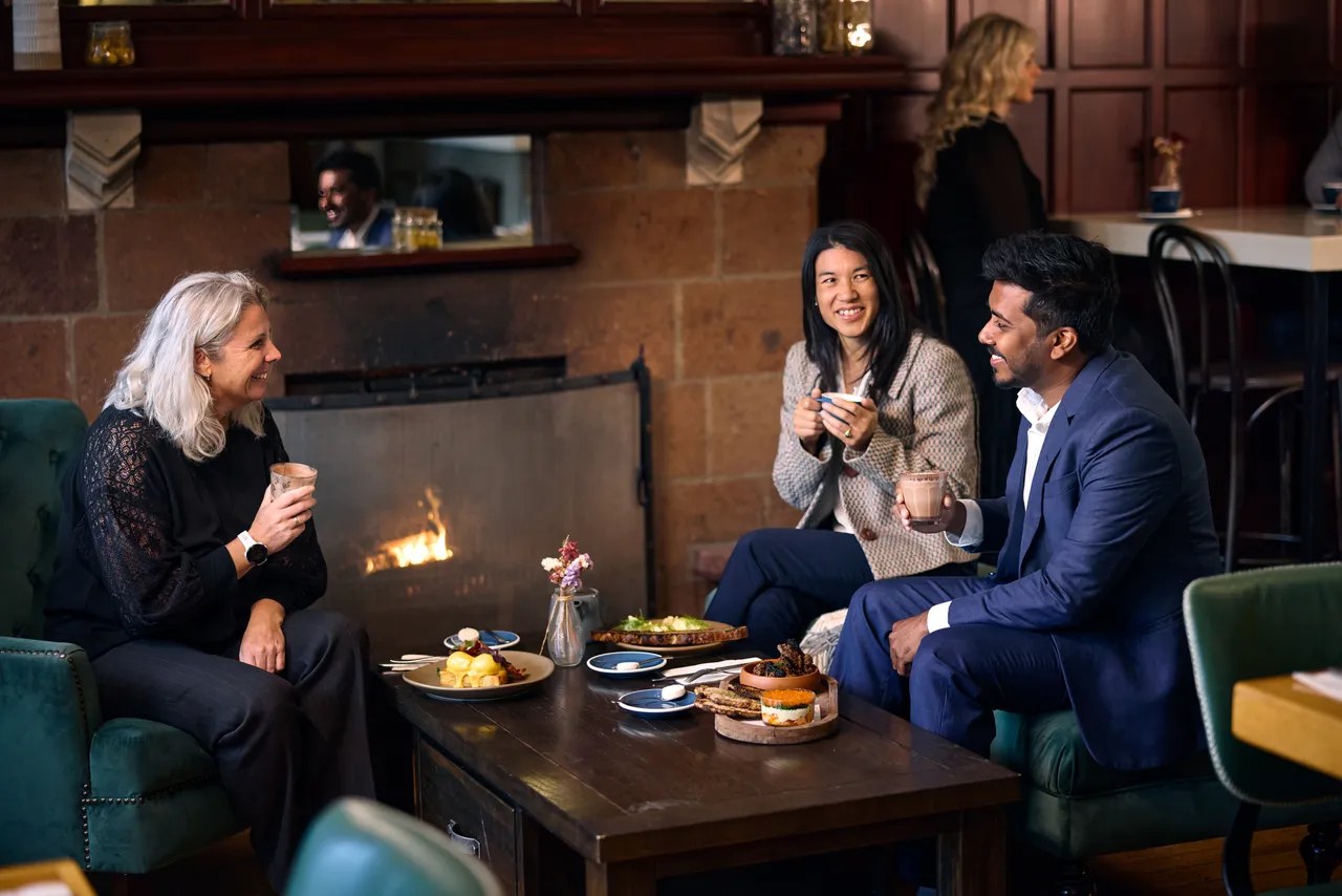Colleagues having brunch by the fire at Miro