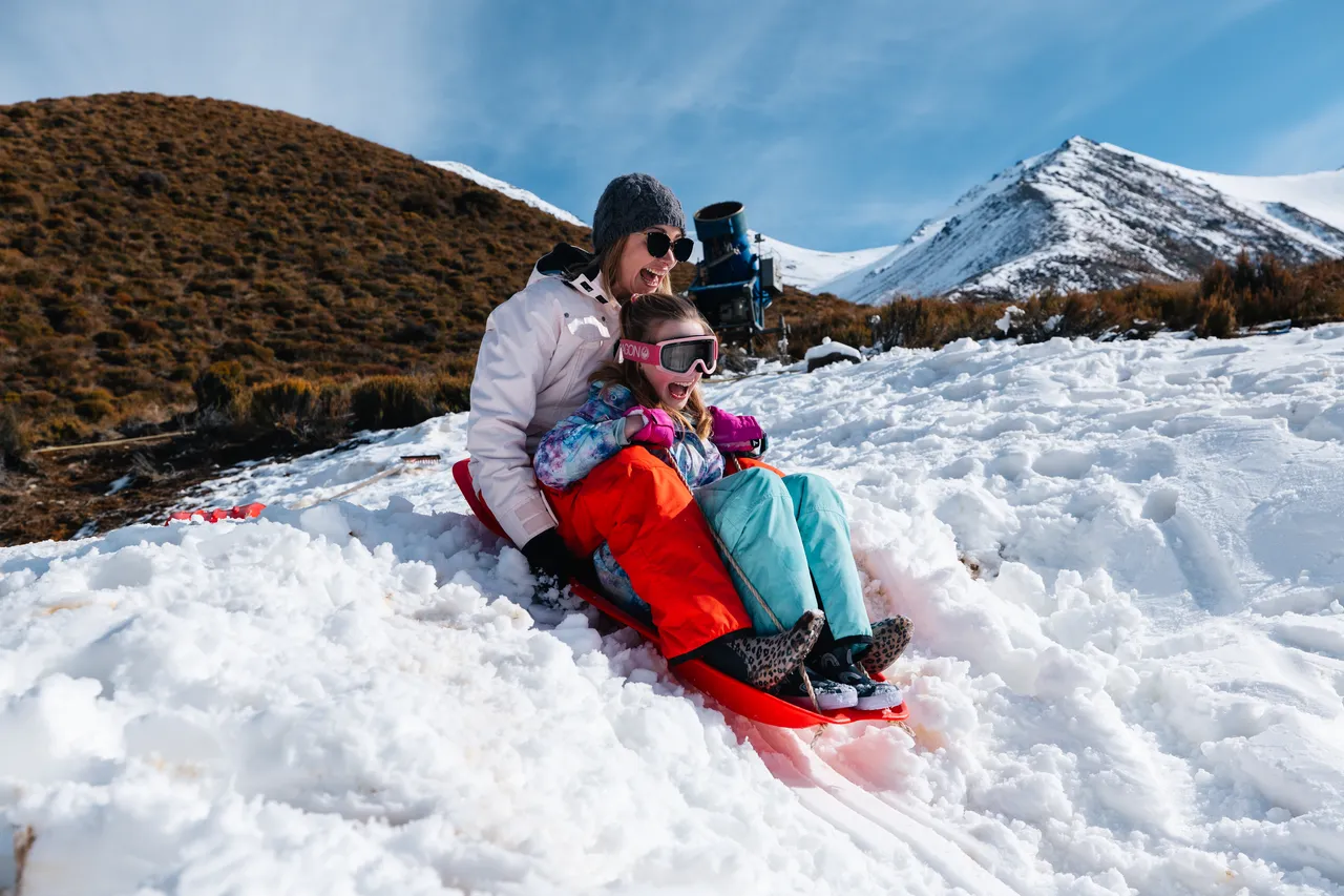Mom and child tobogganing