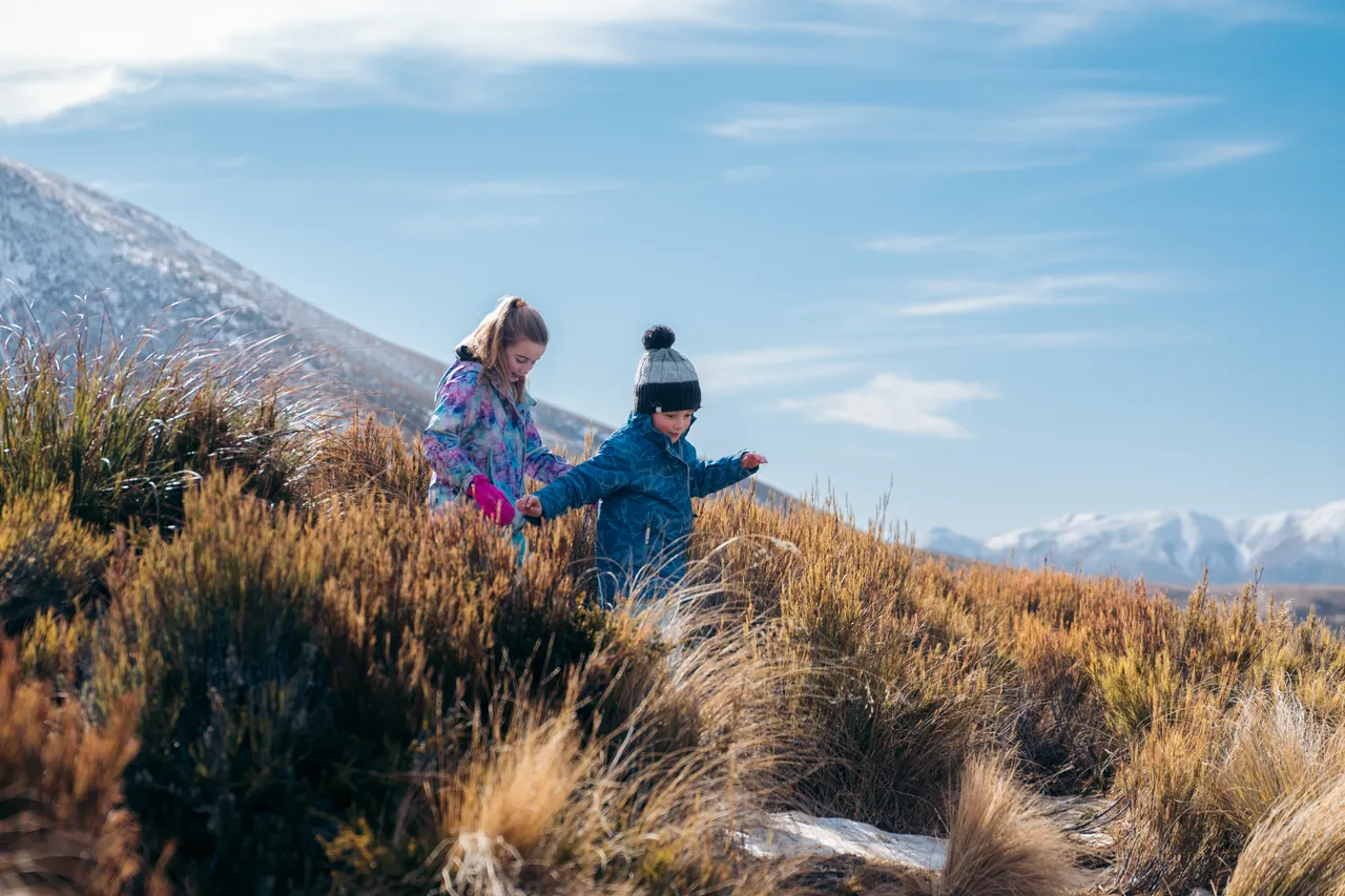 Children walking on snowy hill
