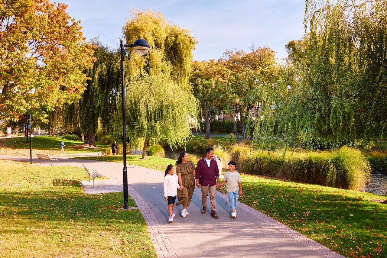 Family walking along the Avon River in Victoria Square