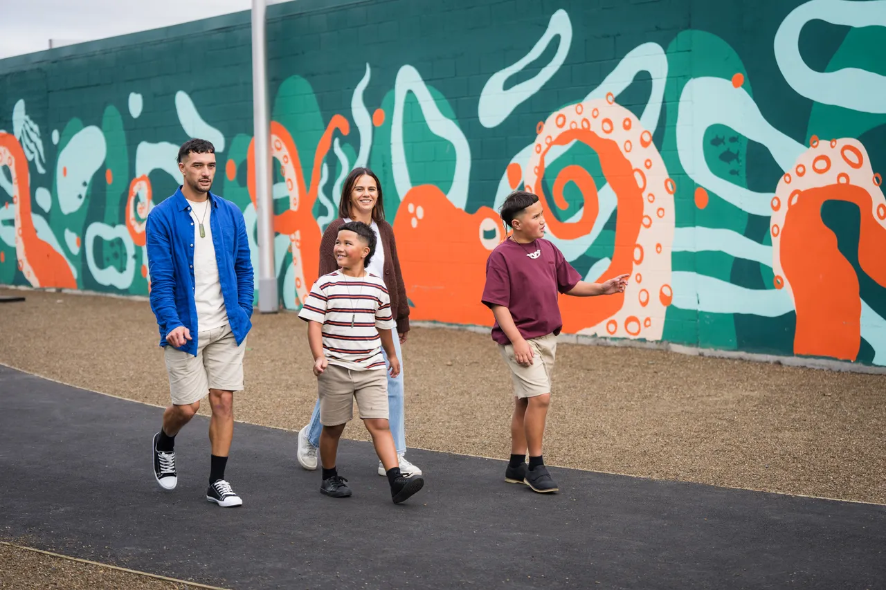 Family strolling along Ocean Alley mural